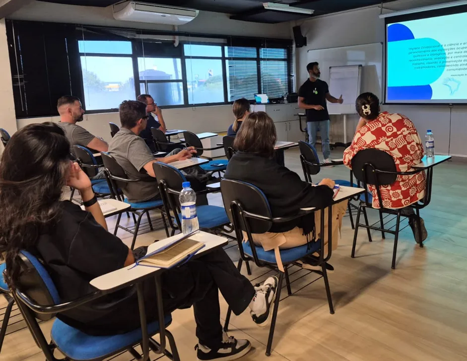 Treinamento em sala com instrutor apresentando conteúdo de higiene ocupacional